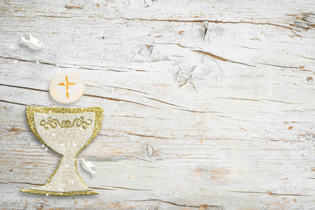 第一次圣餐会邀请银金圣杯和鸽子在白色的木制背景上,空空间的文字和