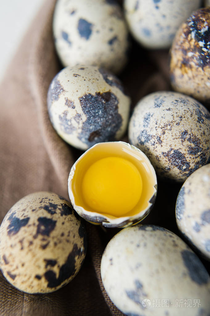 鹌鹑蛋一个破蛋白色背景侧视图关闭