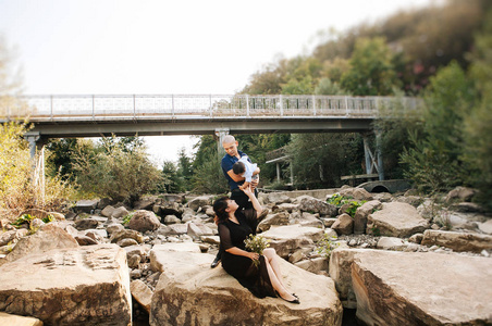 幸福的韩国家庭在河边散步，在山上爸爸妈妈和儿子亚洲人笑着拥抱