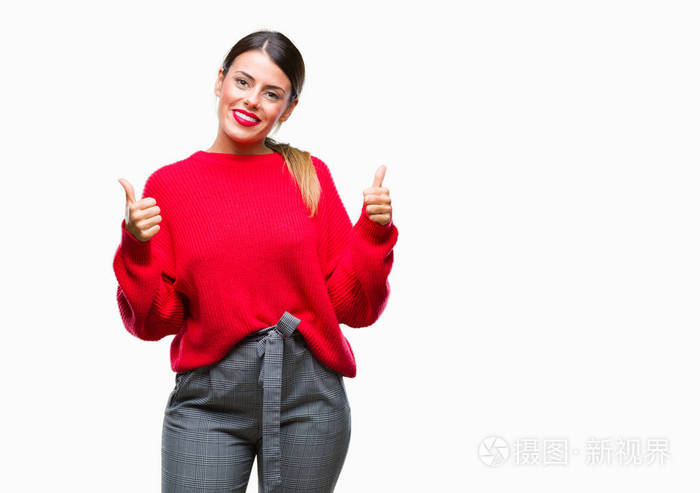 年轻漂亮的商务女性穿着冬天的毛衣，在孤立的背景下，成功的标志，用手竖起大拇指，微笑和快乐地做积极的手势。 用欢快的表情看着相机，