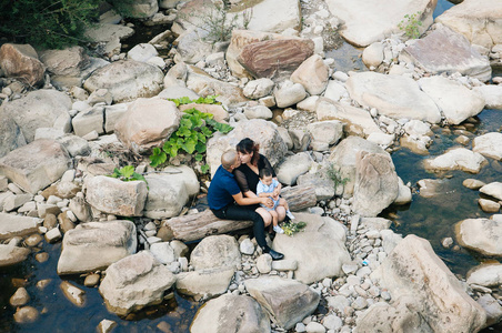 韩国家庭，小儿子坐在石头上