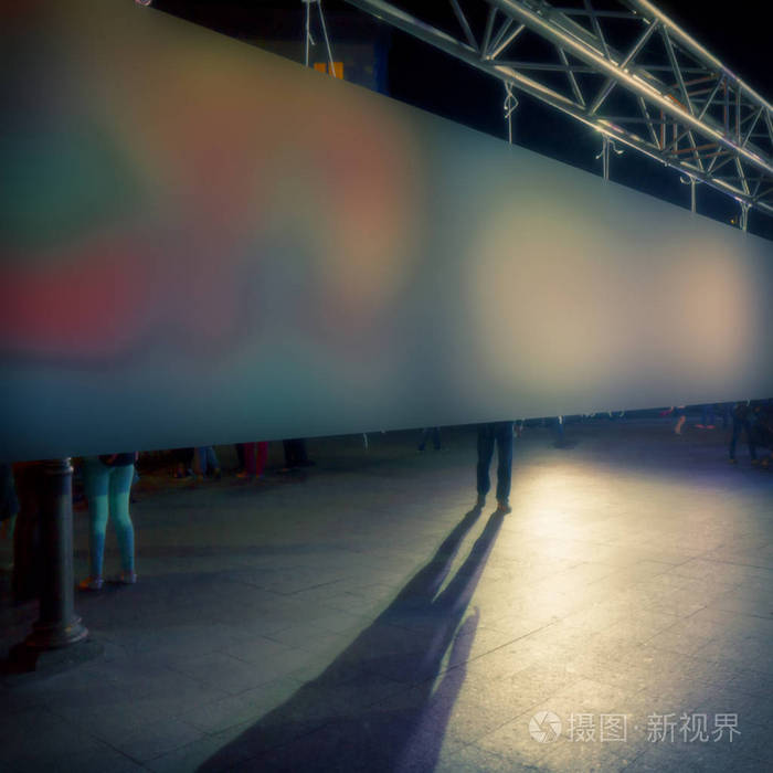 背景模糊的腿和背景中男人的影子照亮了织物