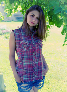 草地背景上一个漂亮女孩的肖像