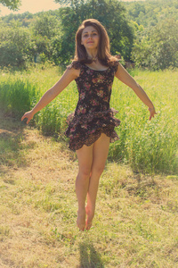 漂亮的女孩跳上草地的背景