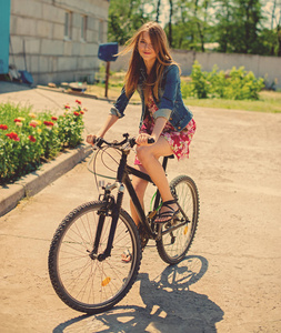 在阳光明媚的夏日骑自行车的女孩