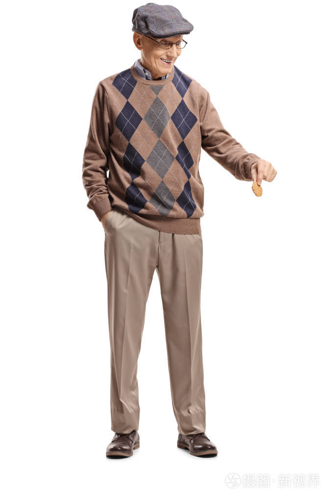 一位老人举着一块饼干俯视着白色背景的全长画像