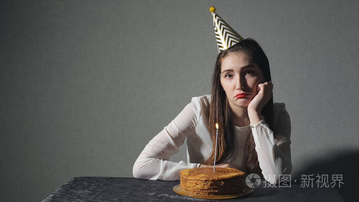 悲伤孤独的女人在庆祝生日独自党帽子