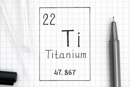 元素的周期表。 手写化学元素钛钛与黑色笔试管和吸管。 快关门。