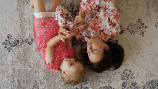 美丽的女人与小女儿在地板上玩