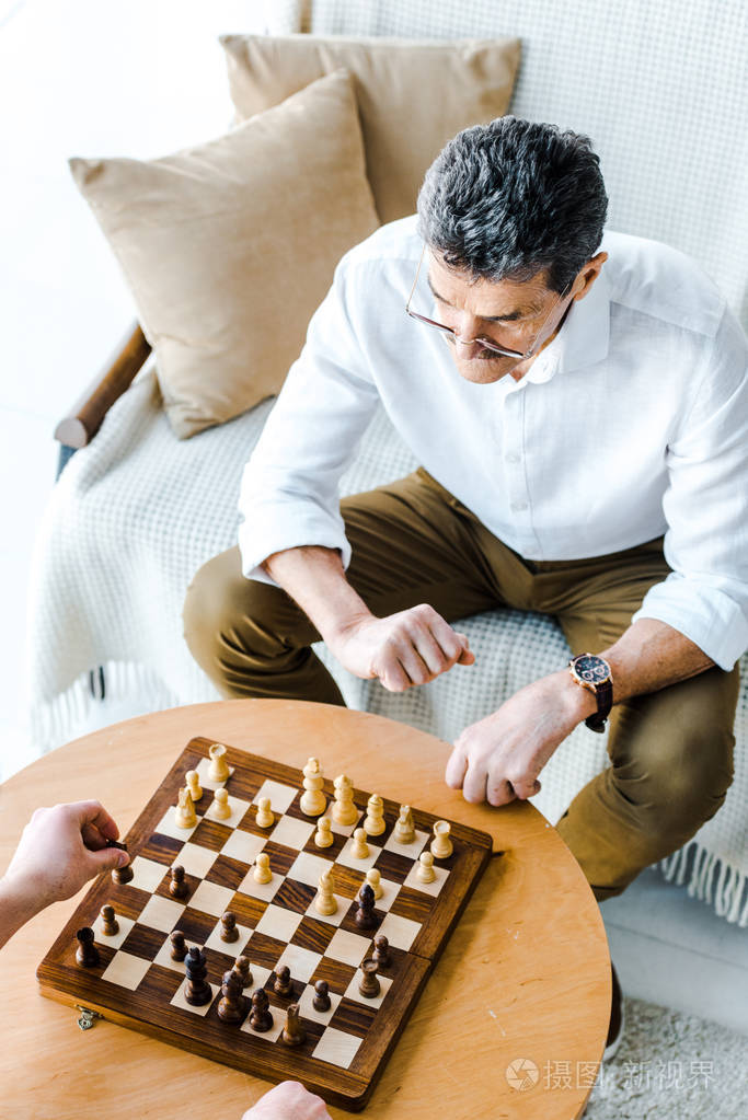 在家下棋的退休男子的俯视图