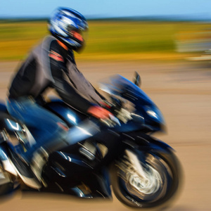 模糊背景骑手高速骑在运动摩托车上