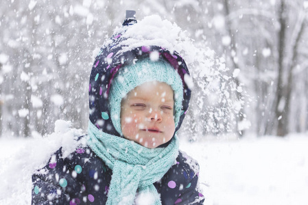 穿冬季连衣裙的婴儿在第一场雪中感到高兴