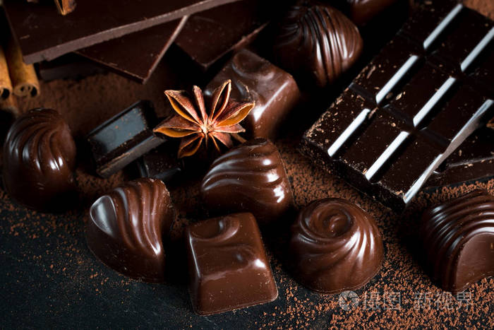 黑白色和牛奶巧克力叠片的种类. 巧克力和咖啡豆在乡村木制的背景上.