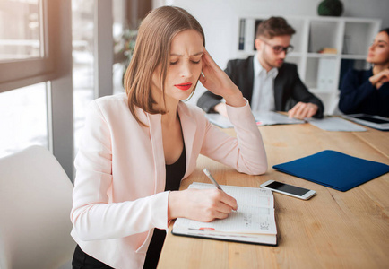 她的同事们在后面工作.她很专注照片