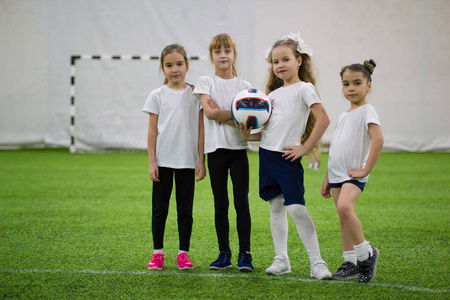 孩子们在室内踢足球。足球队里有四个女孩