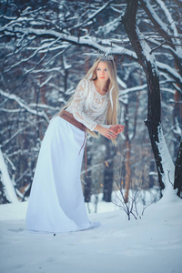 冬天美女。 美丽的时尚模特女孩，在冬天的森林里在冬季森林。 节日化妆和美甲。 有冰雪发型的冬季女王。