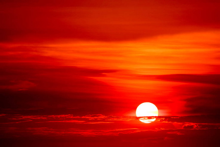 夕阳和五彩缤纷的火焰云剪影树在深红的天空上