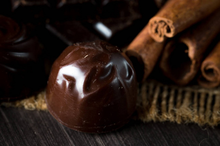 黑白色和牛奶巧克力叠片的种类。 巧克力和咖啡豆在乡村木制的背景上。 香料肉桂。 选择性宏观聚焦。 巧克力背景。 糖果