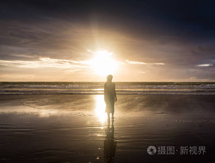 免费女人享受自由快乐海滩在日落时分.
