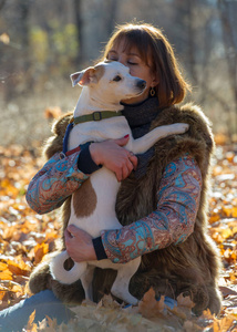 在秋天公园度假的女人带着一只狗，40岁