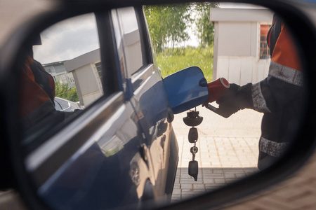 汽车镜子里的人用汽油为汽车加油