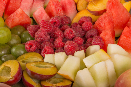 水果混合。 桃子葡萄，苹果，西瓜，瓜，覆盆子，李子。 多汁和成熟的水果碎片接近。