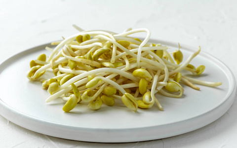 生的黄豆芽放在白色盘子上特写.照片