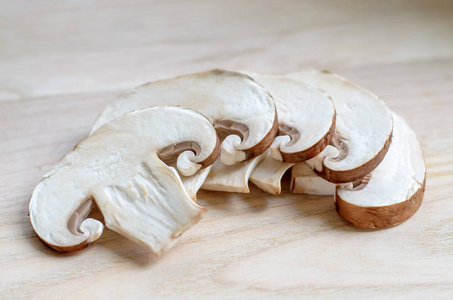 在木制砧板上切成片的新鲜香葱蘑菇。 浅场深特写