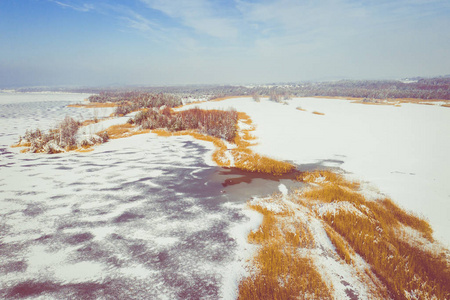 鸟瞰冬季积雪覆盖森林和冰冻湖从上面捕捉到一架无人机。
