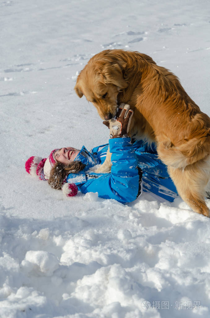 小女孩摔倒在雪上冬天的乐趣金狗出现在她身上