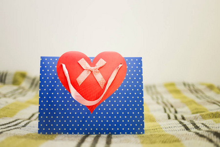 s day. Blue package with red heart on sofa