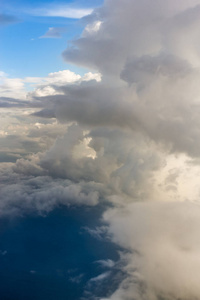 从飞机窗口到地面和云层的视图。