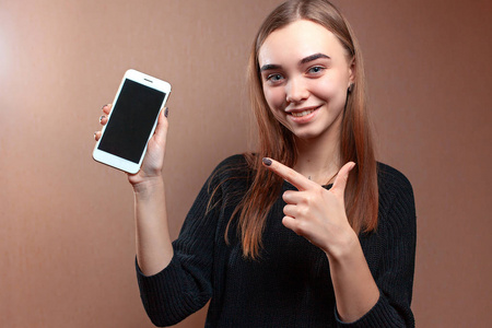 年轻漂亮的女人正指着手中空白的手机屏幕，看着镜头