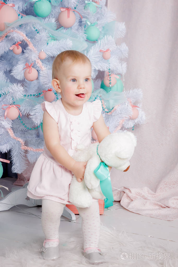 一个可爱的欧洲金发小公主的肖像戴着一件漂亮的连衣裙在一个装饰着