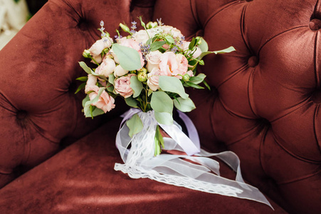 美丽的花米色粉红色紫色玫瑰花束在棕色沙发上