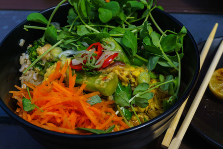 亚洲炒饭与鸡蛋和蔬菜，看到食物和发芽豌豆在焯菜与滑动黄瓜在木制背景。 泰国式食品