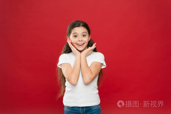 小女孩激动地笑着.孩子快乐可爱的脸感觉兴奋红色背景.