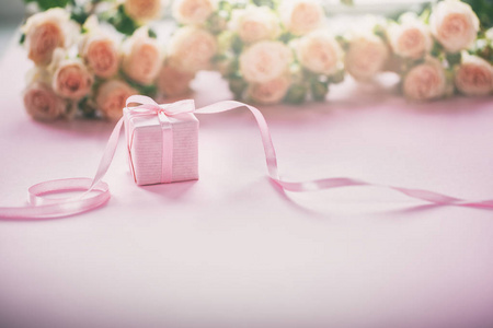 粉红色玫瑰花和礼物或礼物盒粉红色背景。 母亲节生日情人节女人日庆祝概念。 文本空间。
