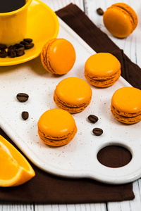 带有黑巧克力和咖啡馅的橙色法国马卡龙. 选择性聚焦.照片