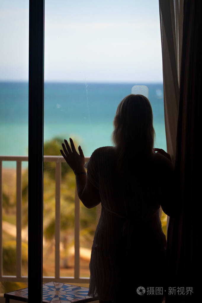 性感的女人剪影在阳台上与海景