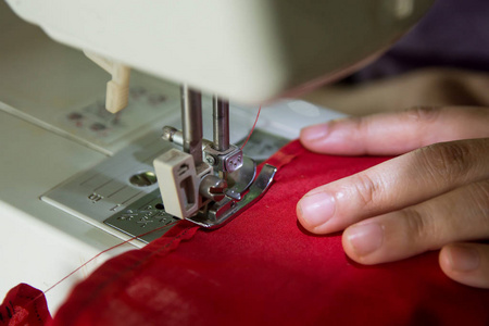 女裁缝在缝纫机上做衣服。