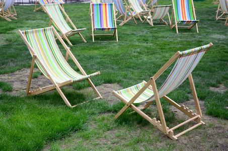 躺椅在草坪上。 在假期的节日里休息。 花园在绿草上晒太阳。 日光浴和休息的花园床。 夏日椅