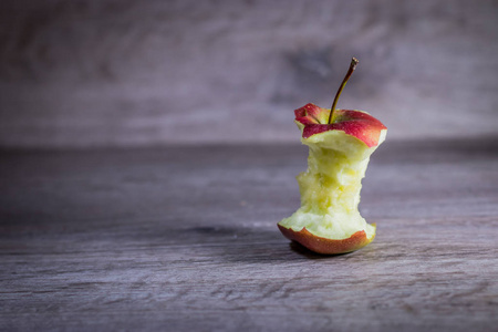被咬的苹果躺在木制的背景上.照片