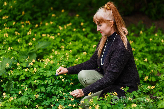 红发女人在草地上采花