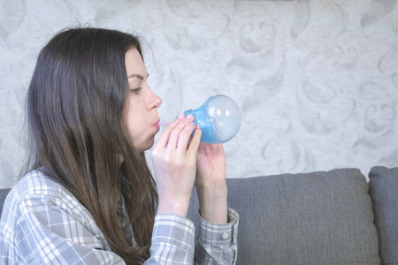 女人用蓝色的黏糊糊的东西膨胀一个大泡泡。玩粘液