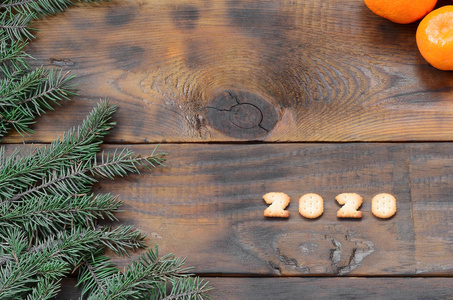 圣诞假日卡与橘子饼干2020数字和冷杉分支与复制空间。 俯视图平躺