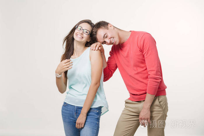幸福的年轻可爱的夫妇站在一起笑了工作室拍摄在白色背景友谊爱情和
