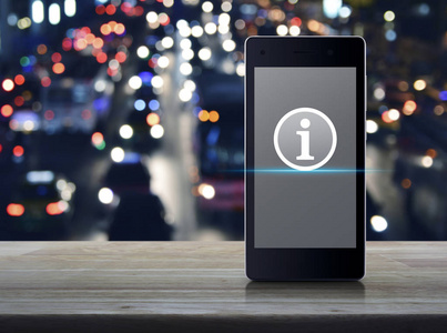 现代智能手机屏幕上的信息标志图标在木桌上模糊的彩色夜光交通堵塞街道上与汽车商业通信在线概念