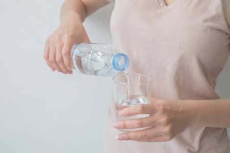 s hand holding a bottle of water Pouring water into a glass