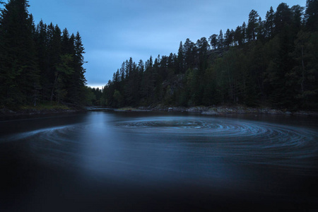 挪威北方森林的夜晚气氛。霍姆拉河上的瀑布。很长的曝光时间。自然光和颜色。